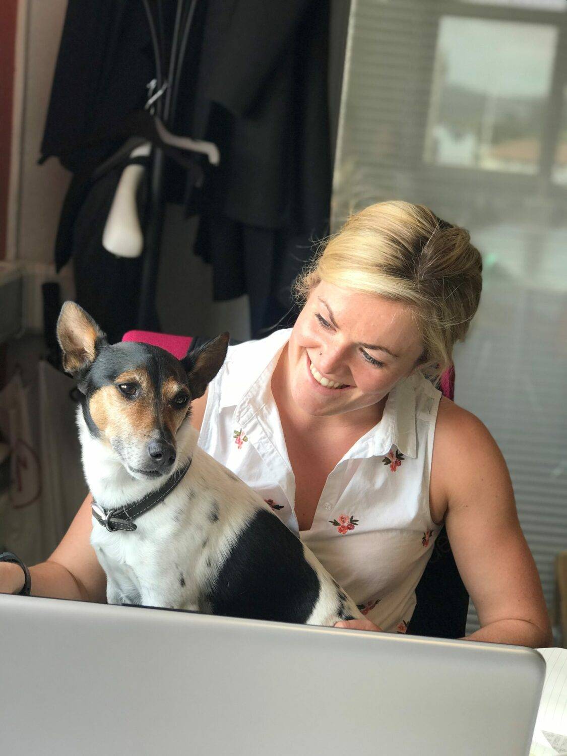 Leanne Stokes sitting in the Denvir Marketing Office with the office boss, Charlie the dog, sitting with her