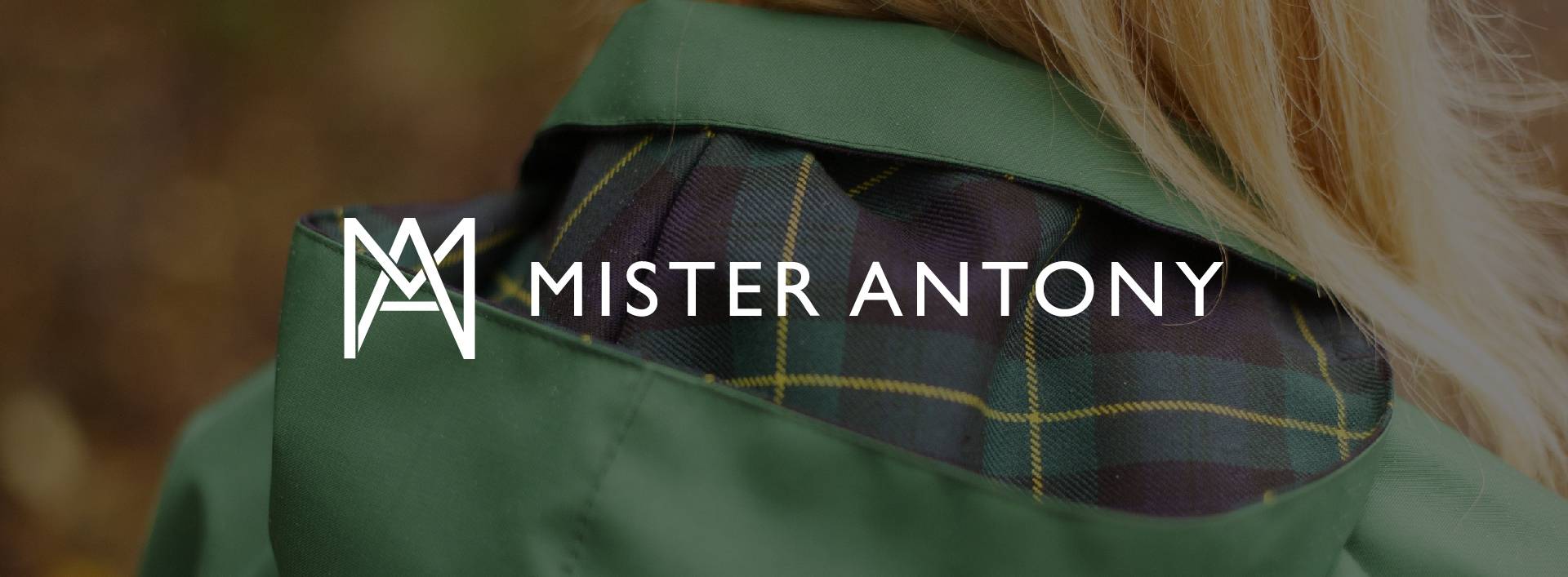 Mr Anthony logo in front of a woman wearing a green anorak